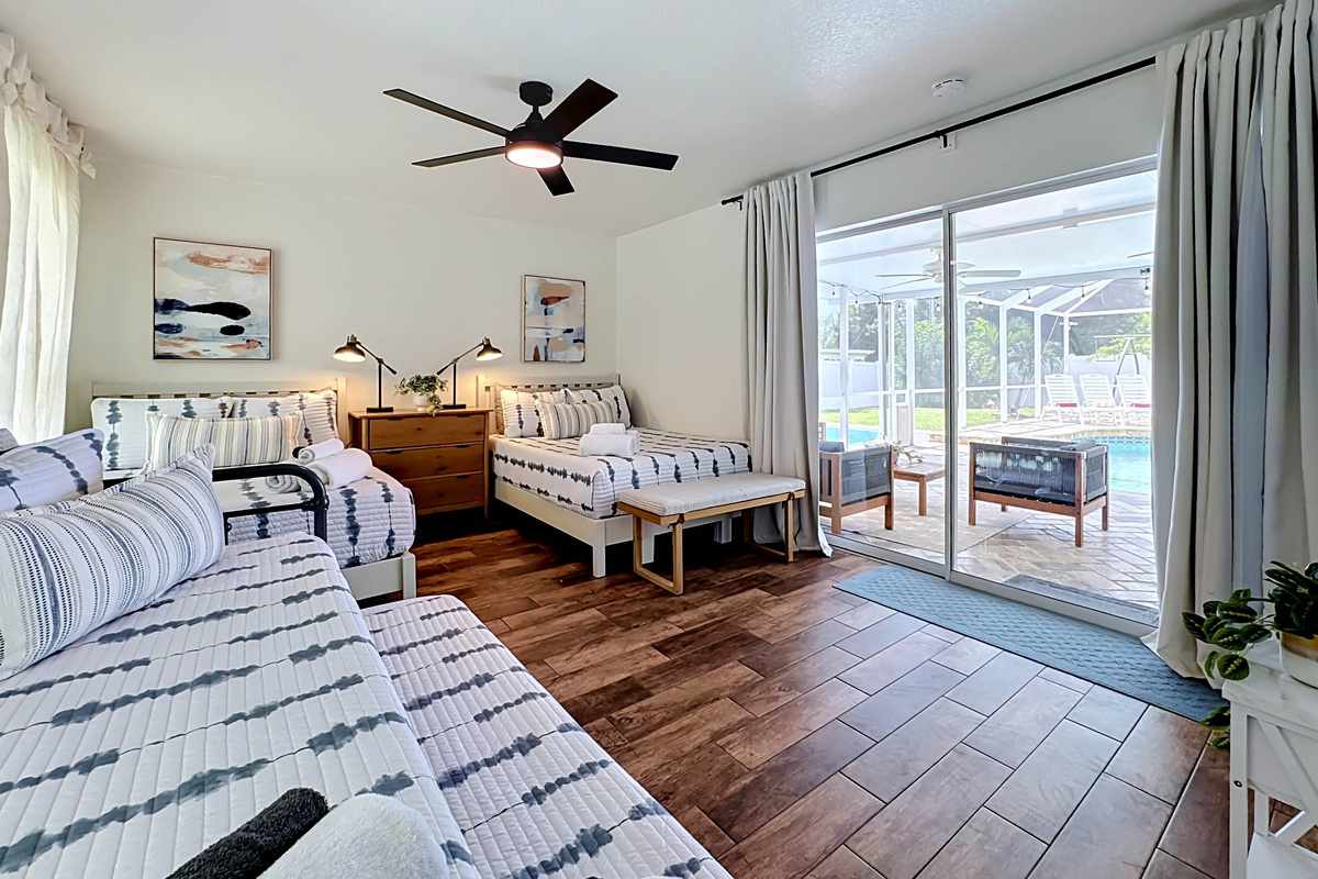 Wake up steps from the pool in this cozy bedroom, with 2 full beds and a daybed with a trundle, and private sliding-door access.
