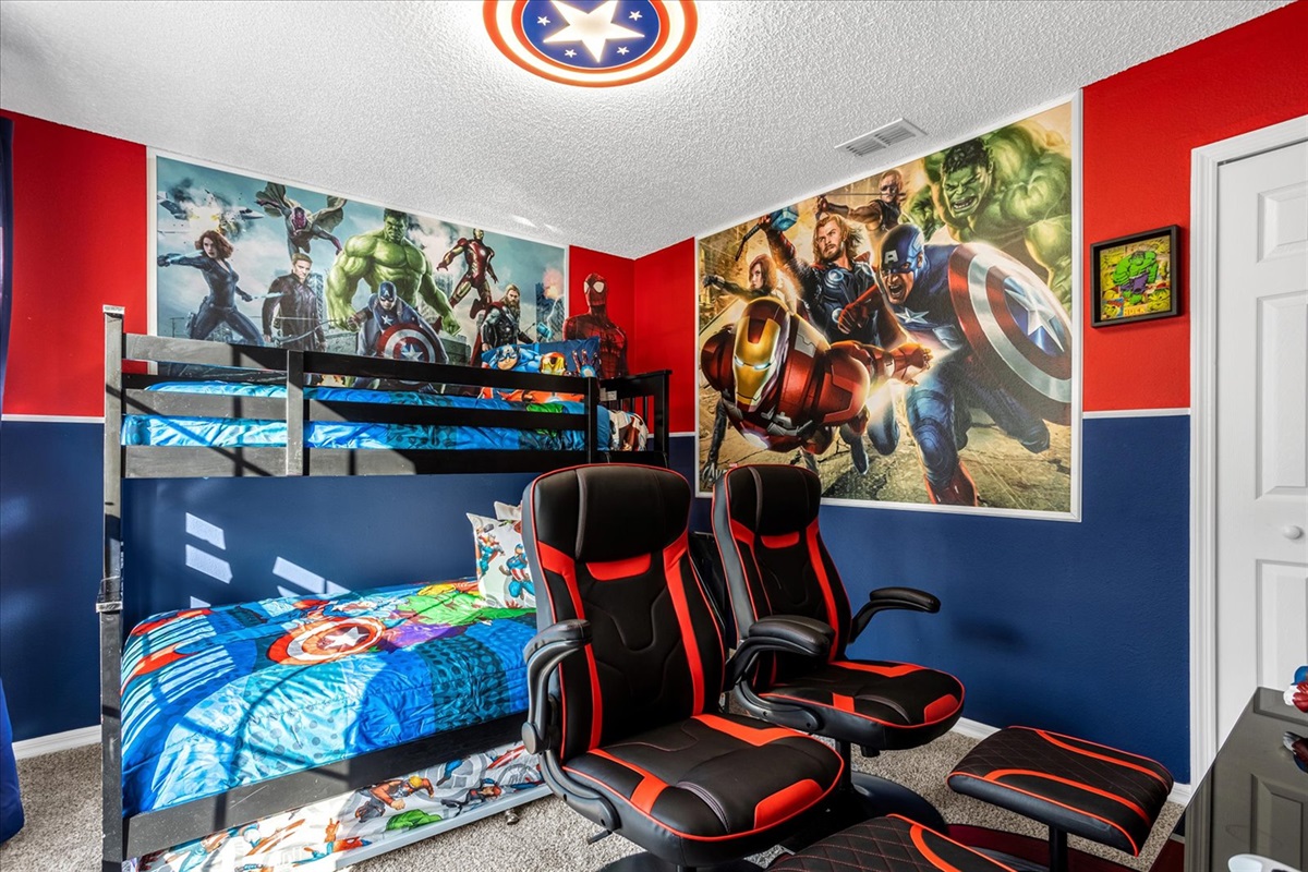 Marvel-themed bedroom with bunk beds and gaming chairs and Xbox  for a fun stay.