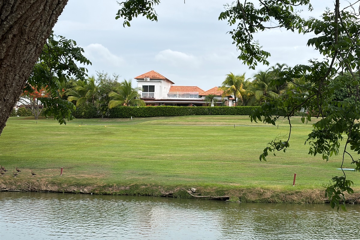 View of the back of the house from across the lake on the golf course