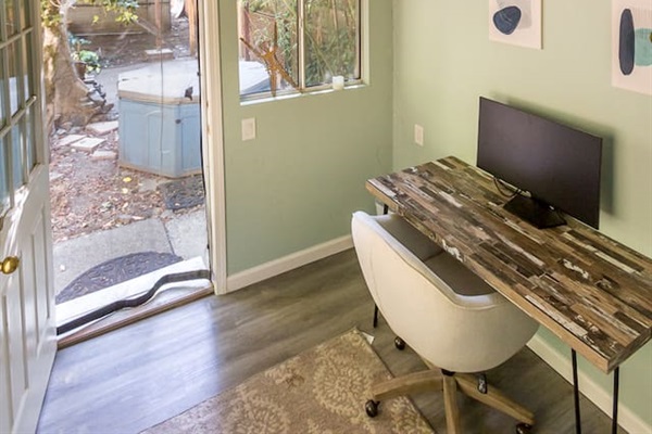 - Bright workspace with rustic desk, modern chair, and wall art
- Sliding door opens to garden views for inspiration and fresh air
- Loft area above adds a unique architectural touch to the space
