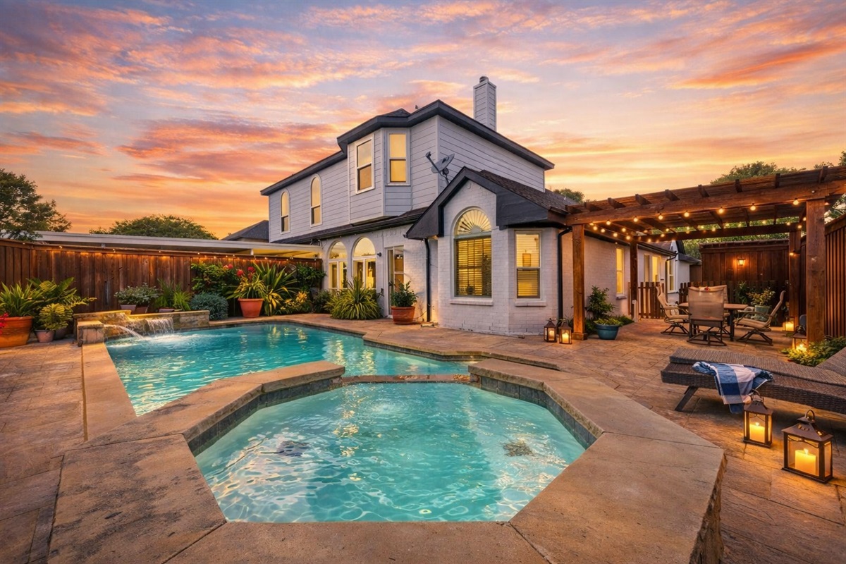 Private resort-style backyard with sparkling pool, spa fountain, and ambient string lighting.