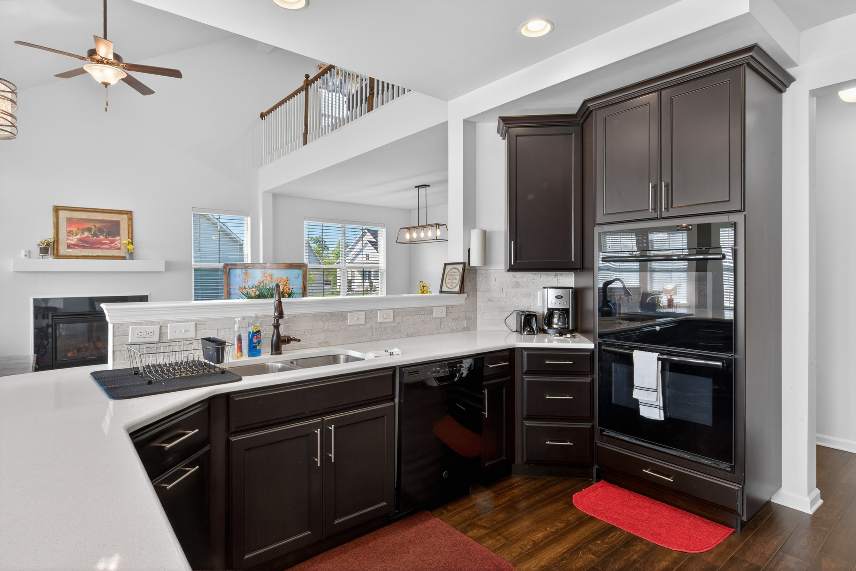 Executive kitchen with granite countertops, stainless steel appliances, double wall ovens, and expansive prep island.