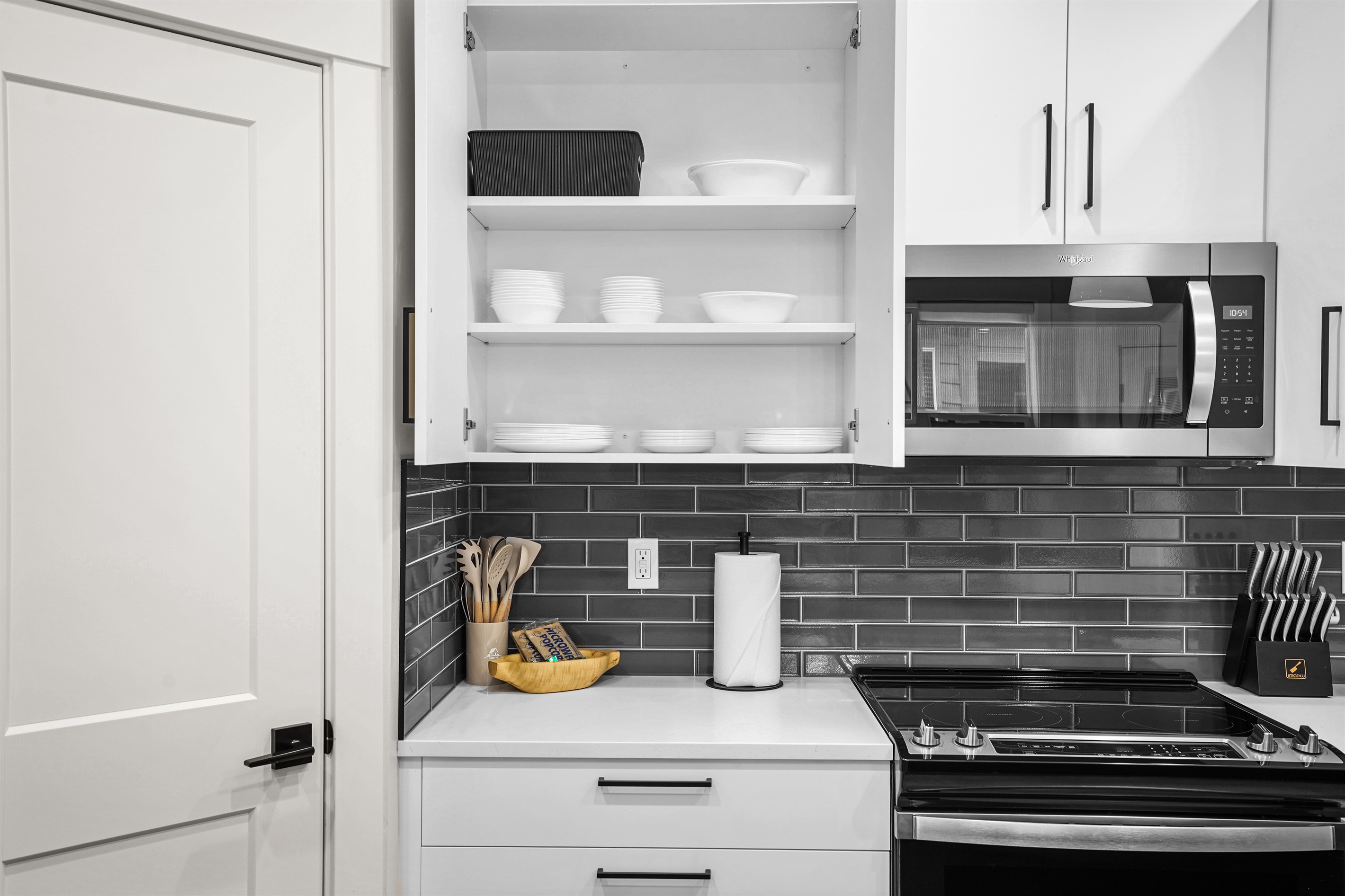 Stay organized in this modern kitchen featuring fully stocked glassware cabinets.