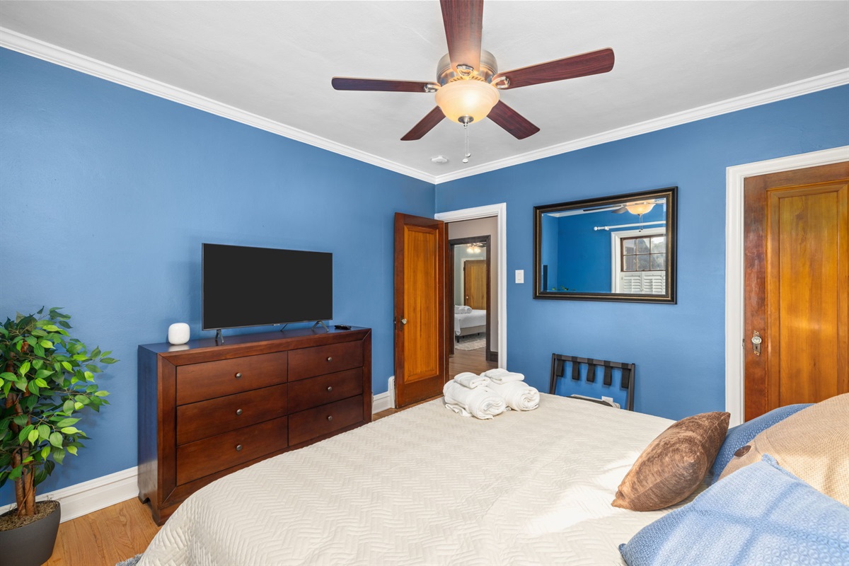 Main level bedroom 1 with King size bed, 43" flat screen smart TV, night stands and bedside lamps with USB charging stations and ceiling fan.  Dresser and closet for storage.