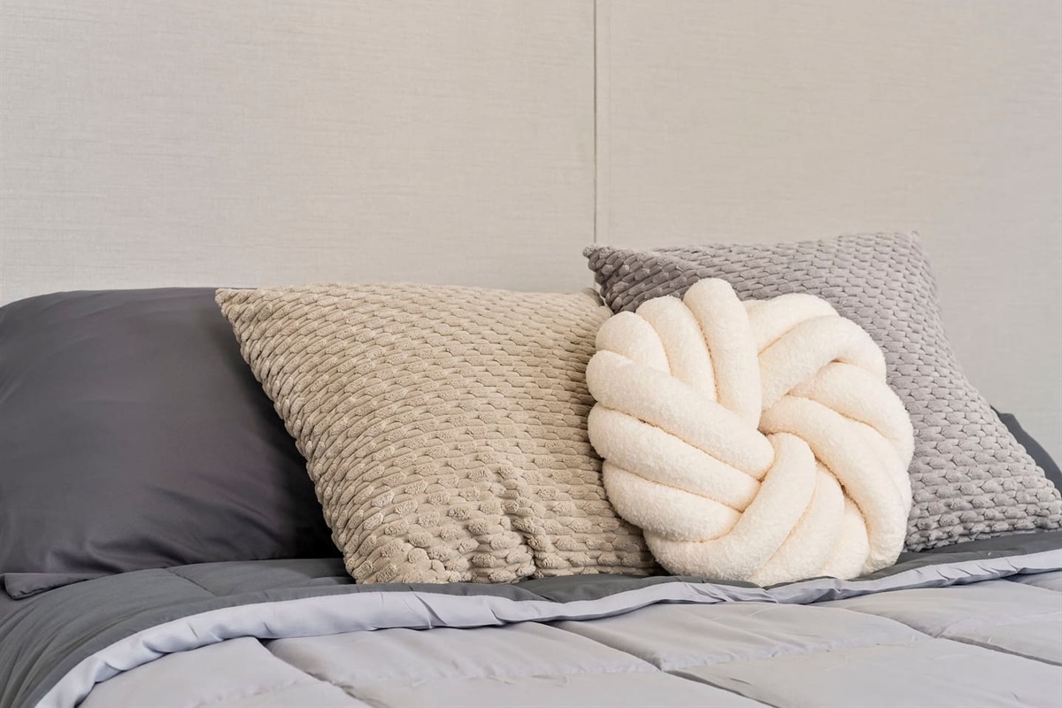 Another angle of the bed highlighting the layered pillows and comfortable sleeping setup.