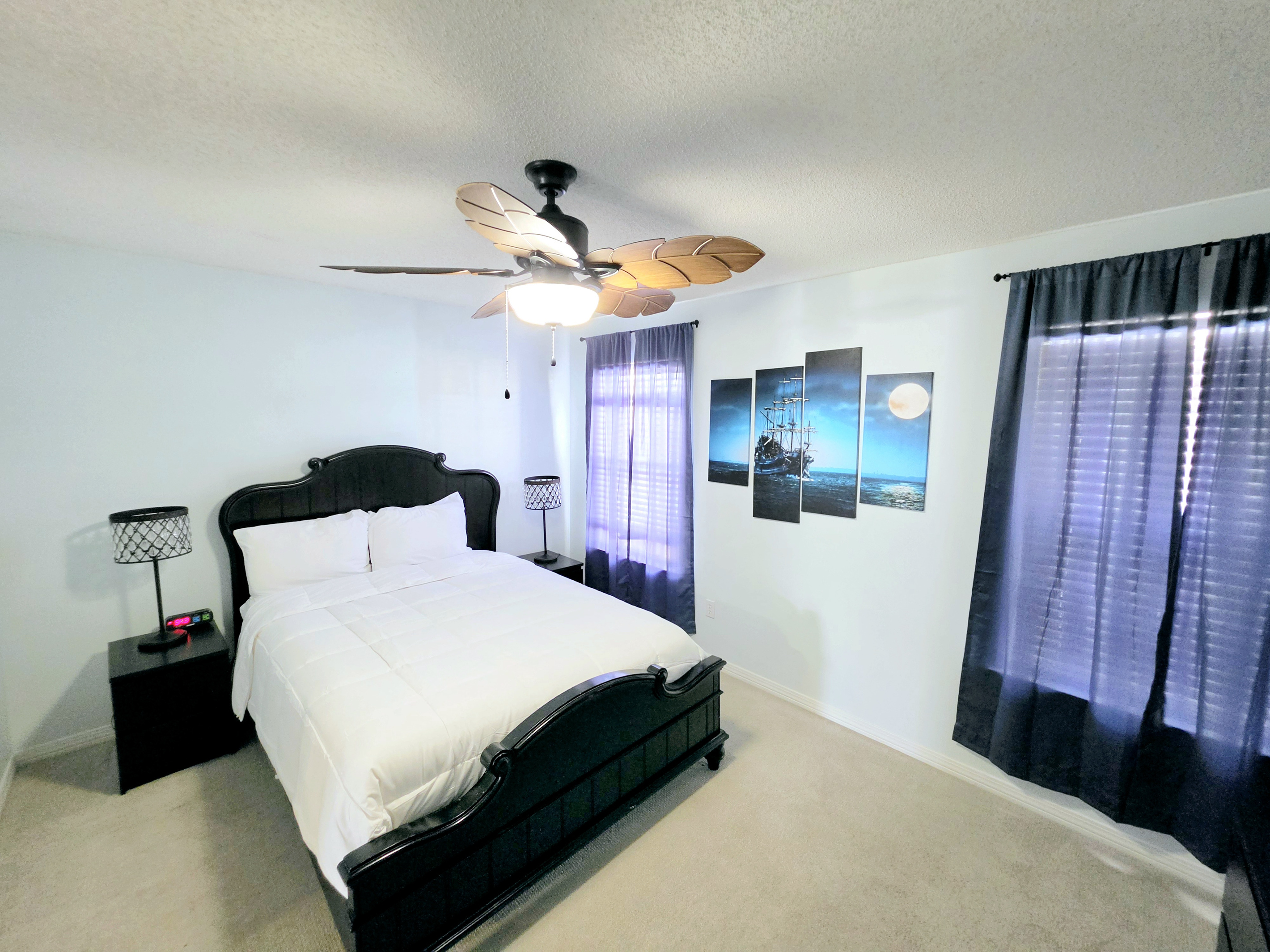 Bedroom with ceiling fan and nautical wall art