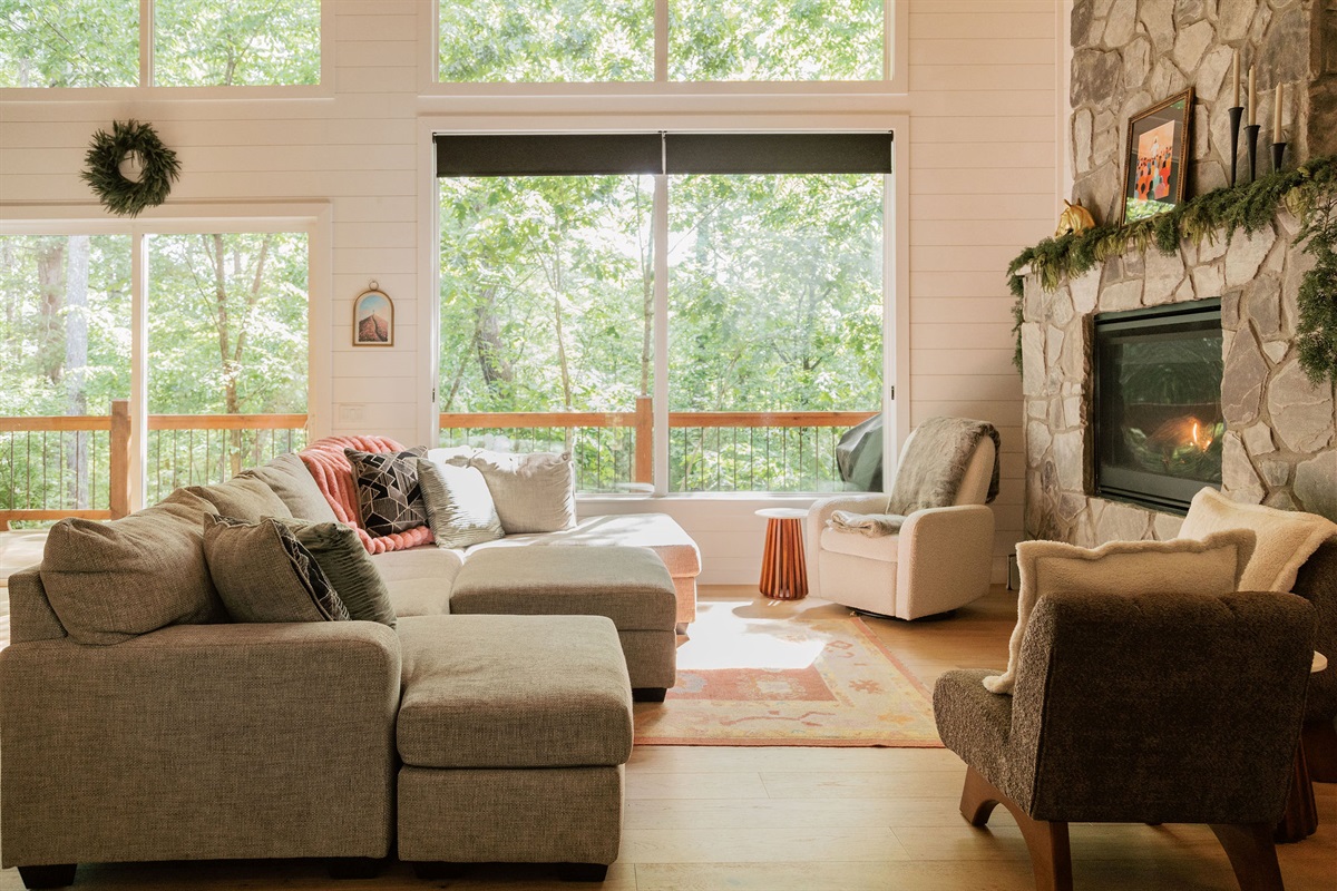Main cabin living room with large windows and forest views.