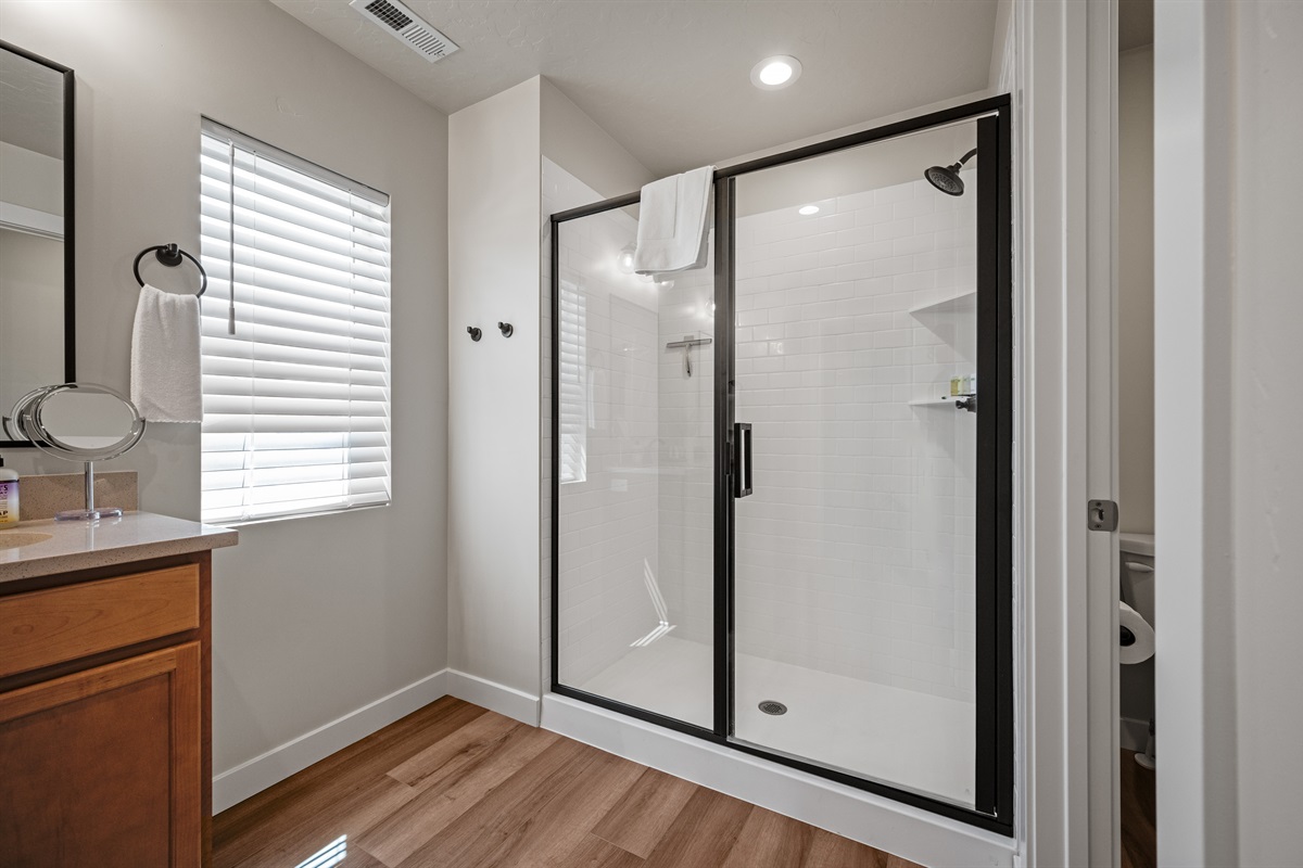 Refresh in the large glass-enclosed shower, complete with shelving for your toiletries and spa-like comfort.