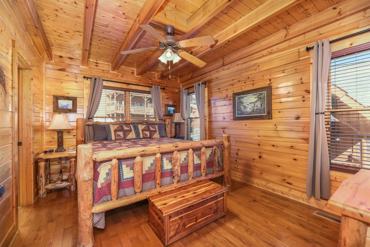- Charming log bedroom featuring a rustic bed frame and soft cabin lighting   - Surrounded by natural wood walls and warm tones for a restful atmosphere   - Wake up to serene Smoky Mountain mornings in cozy comfort