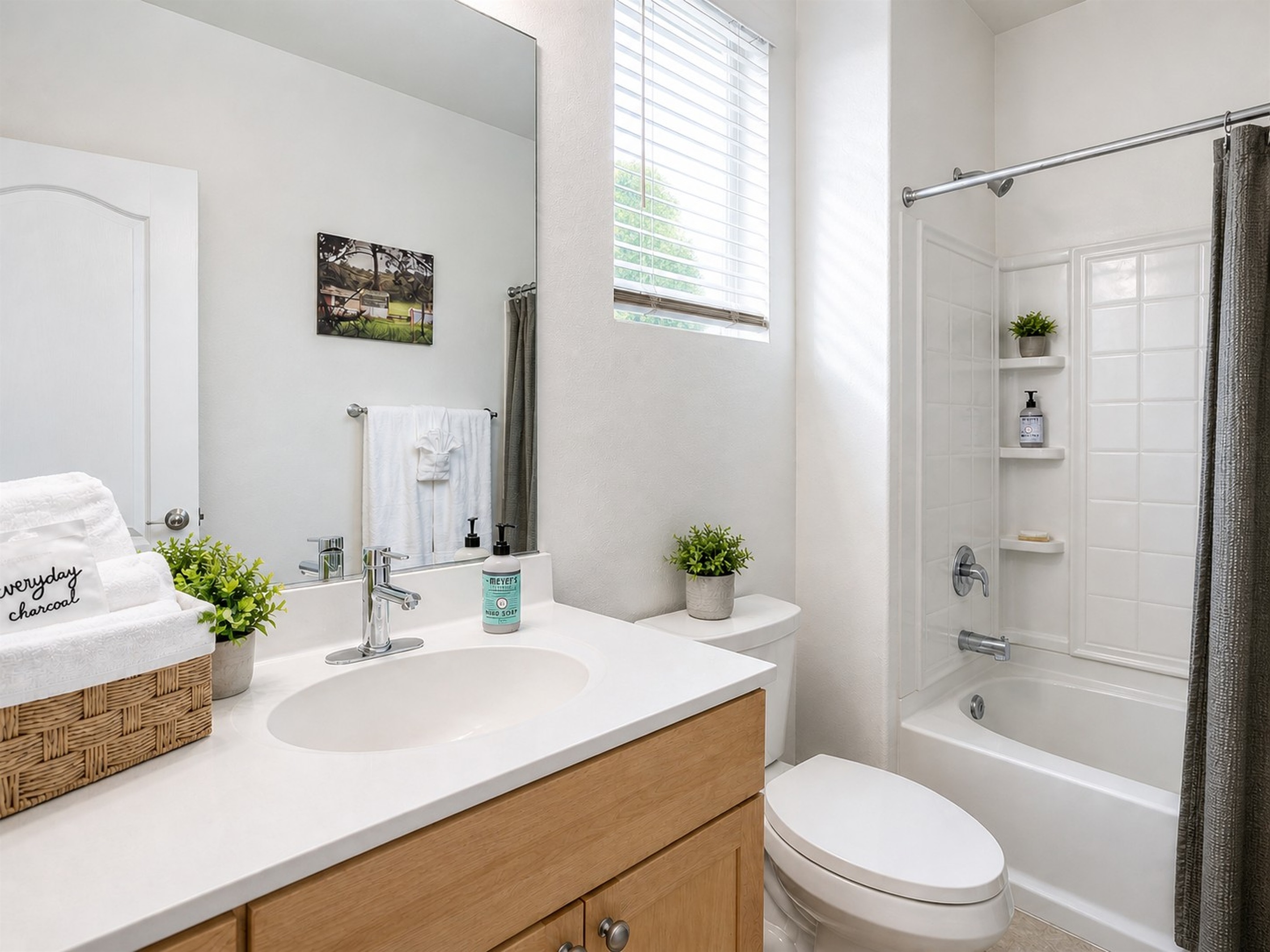 Bright first-floor bathroom with tub and shower, located across from Bedroom 1