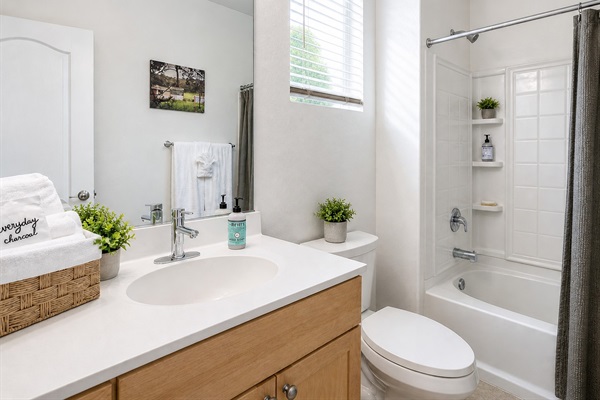 Bright first-floor bathroom with tub and shower, located across from Bedroom 1