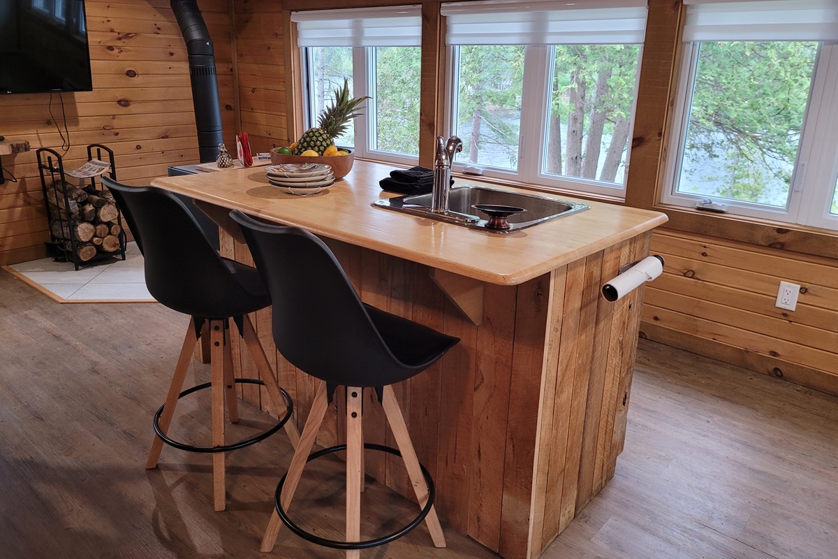 The kitchen island is the perfect place to enjoy breakfast or a snack while enjoying the lake view through the windows