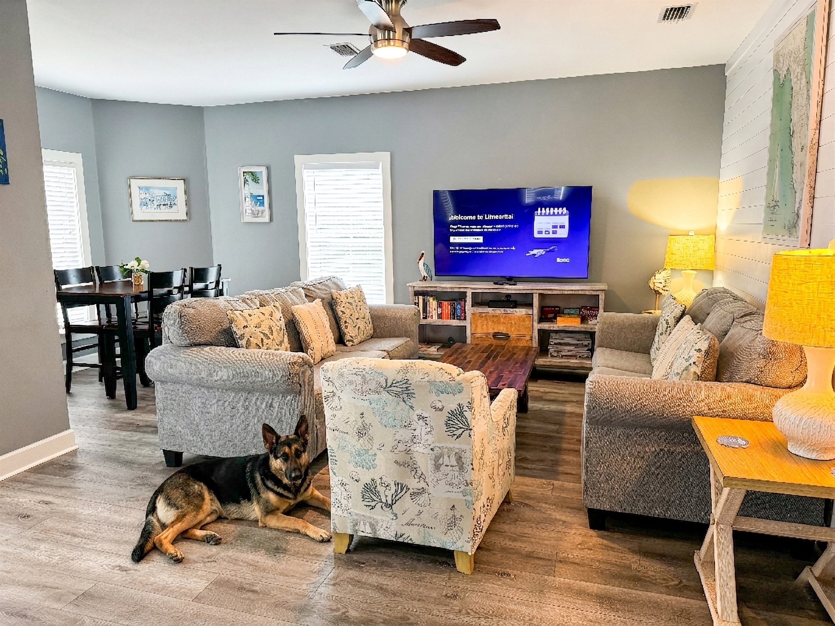 Comfortable living room with 65" flat screen TV. Plenty of viewing space on the two sofas, pub table, and from the dining area. Enough space for everyone, including your furry companion.