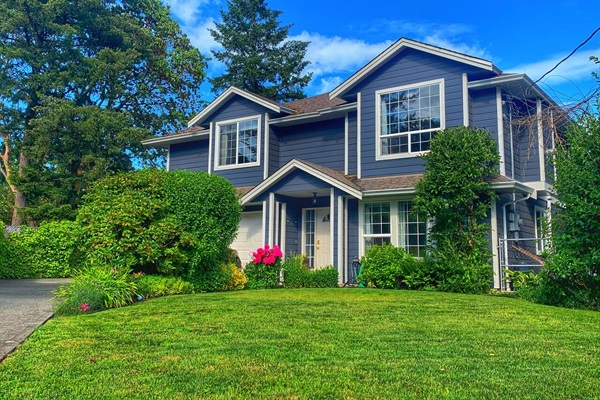 Front of home with driveway and guest parking to the left