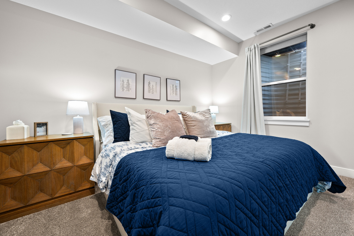 Inviting lower-level king bedroom featuring plush bedding, bedside lighting, and a peaceful atmosphere for restful nights.