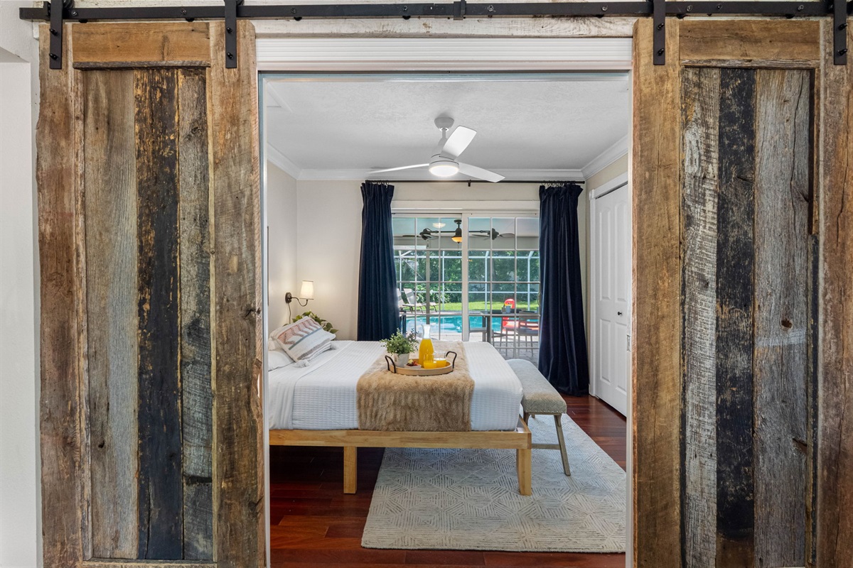 A cozy bedroom with direct backyard and pool views, perfect for morning sunshine.