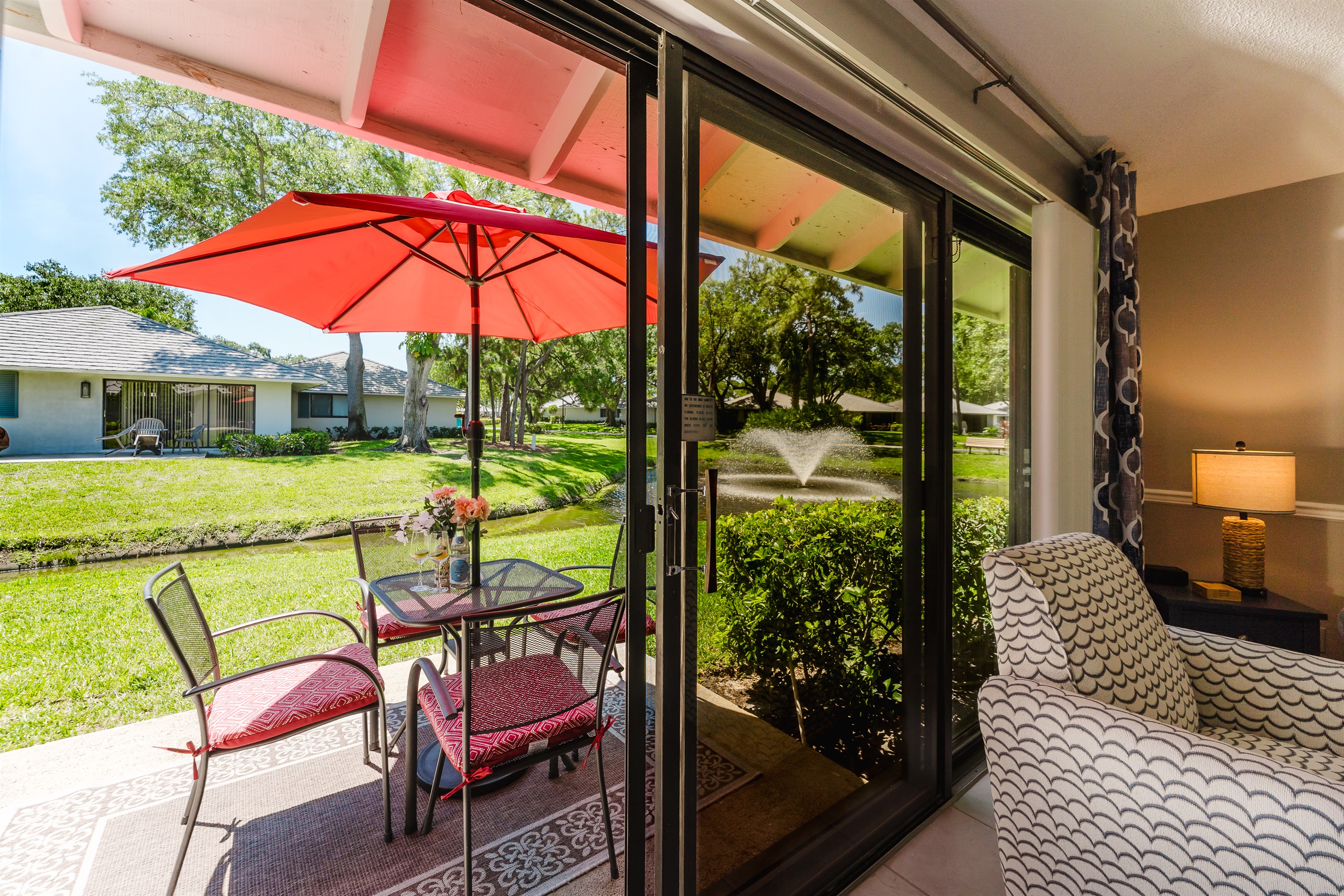 Private lakeside patio with outdoor dining, umbrella, and grill—perfect for morning coffee or sunset meals by the water
