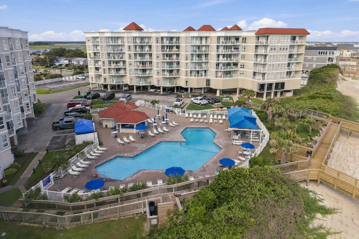 Aerial view of the resort complex showing the outdoor pool, beach access, and ocean.