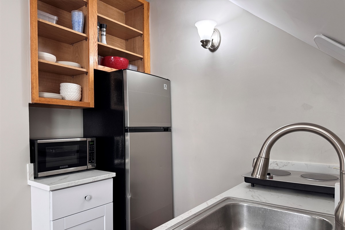 Mid size refrigerator with freezer and microwave provided in this well designed kitchen.