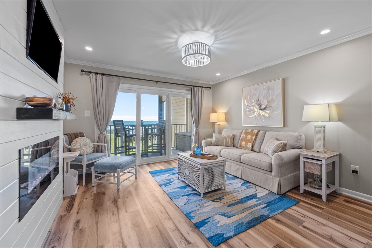 Relax in a bright, coastal living space with ocean views just beyond the balcony