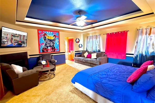 Spacious master's bedroom with a king bed, queen pull-out couch, cozy armchairs, and a Smart TV—perfect for relaxing in comfort
