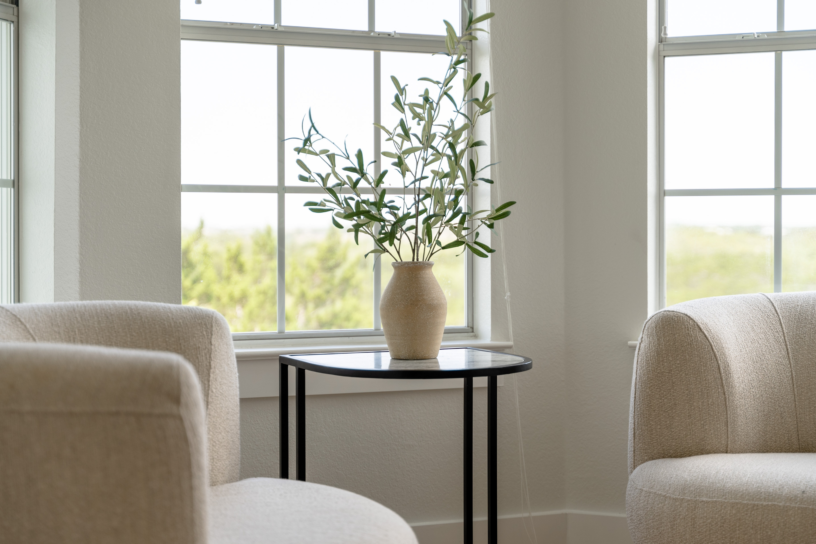 Elegant sitting area with cream armchairs, ideal for morning coffee.