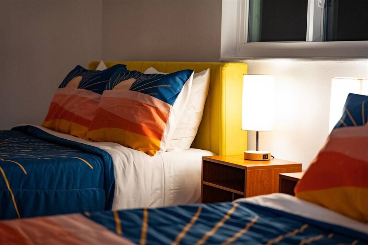 Bedroom with 2 queen size beds. Glass door opens to the dining room and overlooks the pool.
