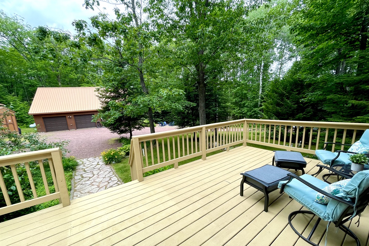 Main cottage front deck facing driveway and other cottage. Large pine trees to the right give some privacy between cottages 