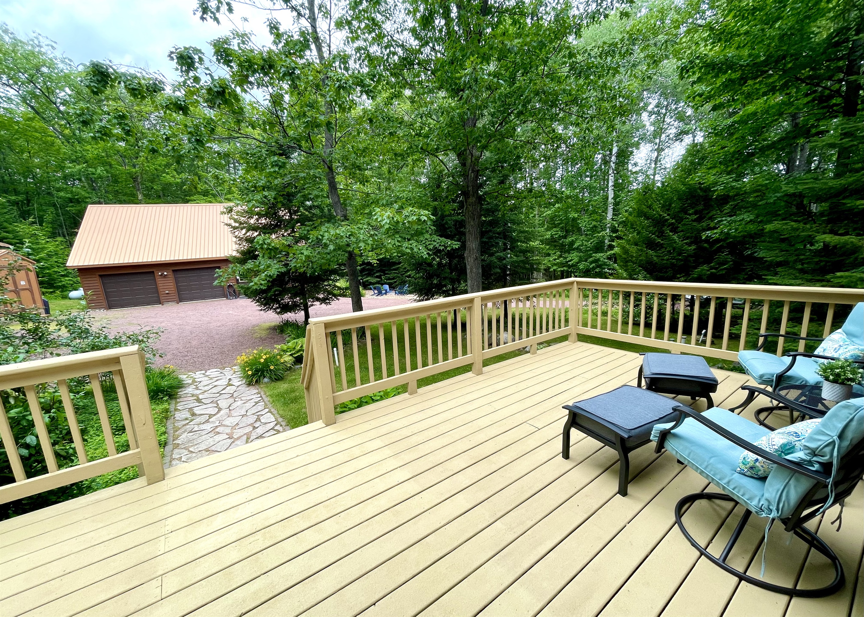 Main cottage front deck facing driveway and other cottage. Large pine trees to the right give some privacy between cottages 