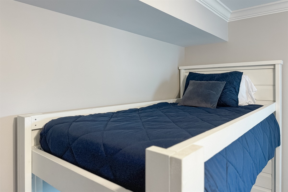 Versatile bunk bed in one of the guest rooms offering comfortable accommodations for guests or family. This space maximizes functionality and style, providing a cozy and inviting atmosphere.