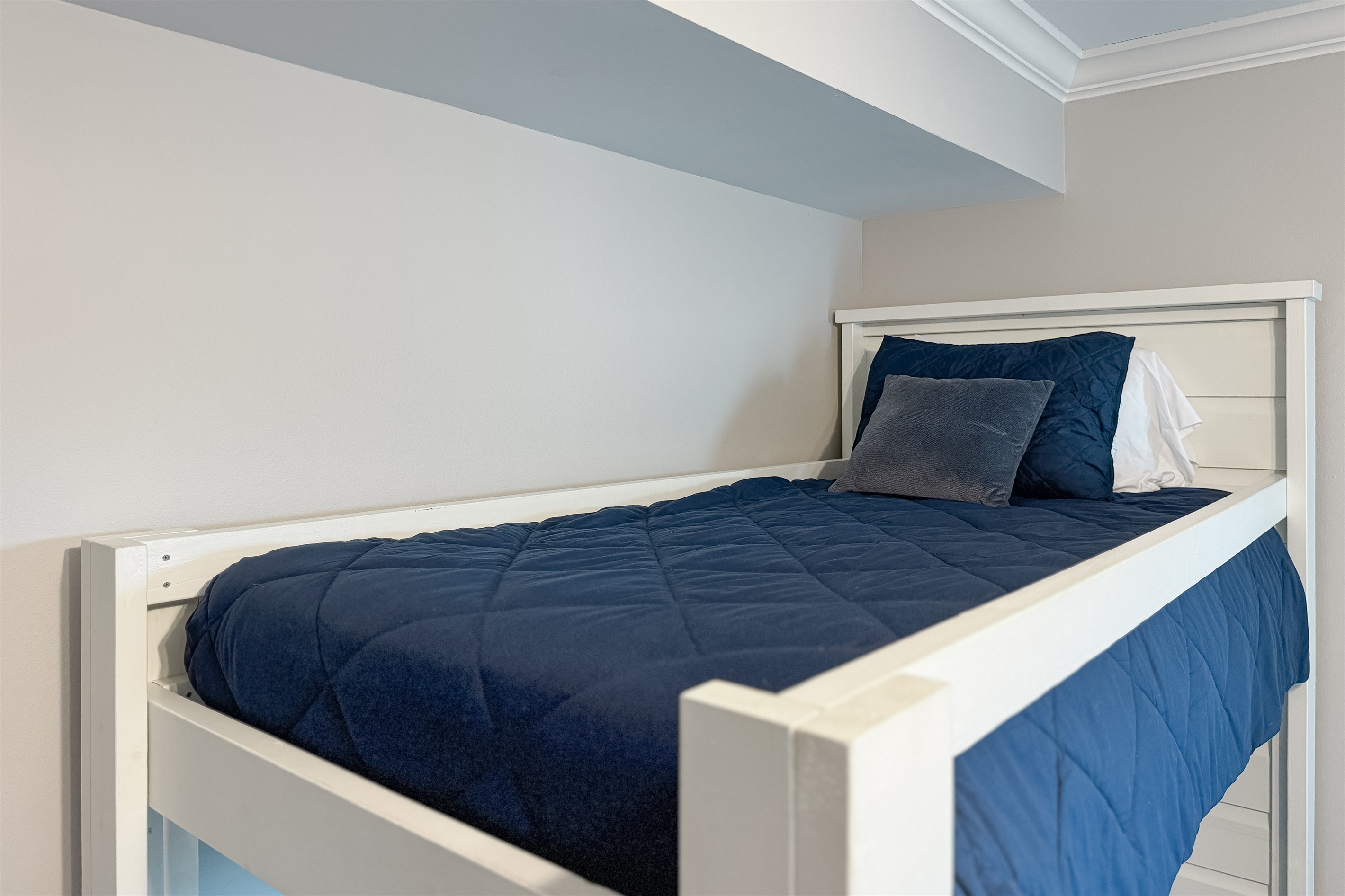 Versatile bunk bed in one of the guest rooms offering comfortable accommodations for guests or family. This space maximizes functionality and style, providing a cozy and inviting atmosphere.