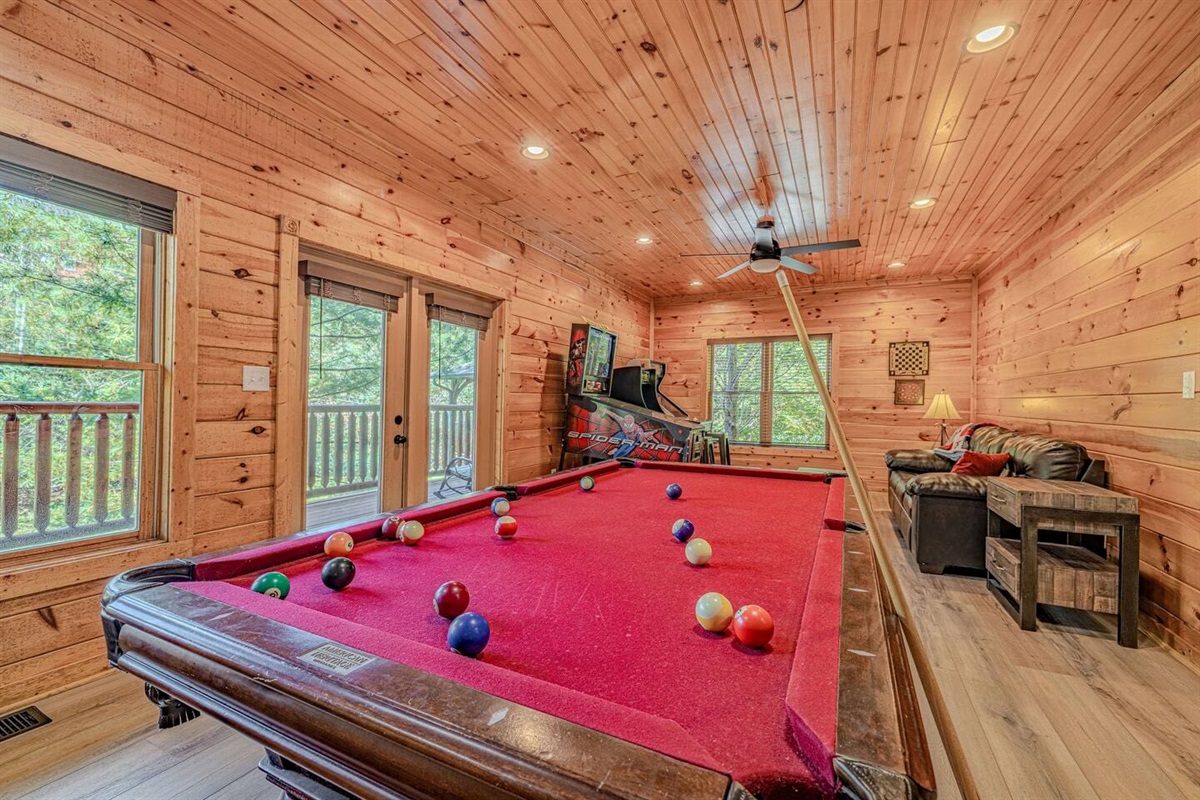 Full arcade game room with pinball, arcade cabinets, pool table, and air hockey. Gatlinburg cabin with game room &mdash; Rocky Top Sports World and Cal Ripken tournament lodging.