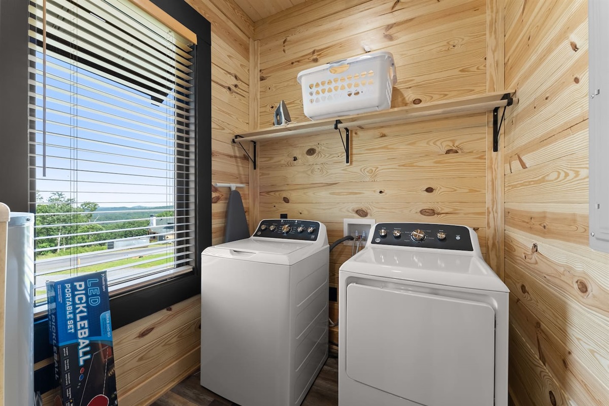 Enjoy the convenience of a private laundry room featuring a washer, dryer, ironing essentials, and scenic mountain views to brighten chore time.