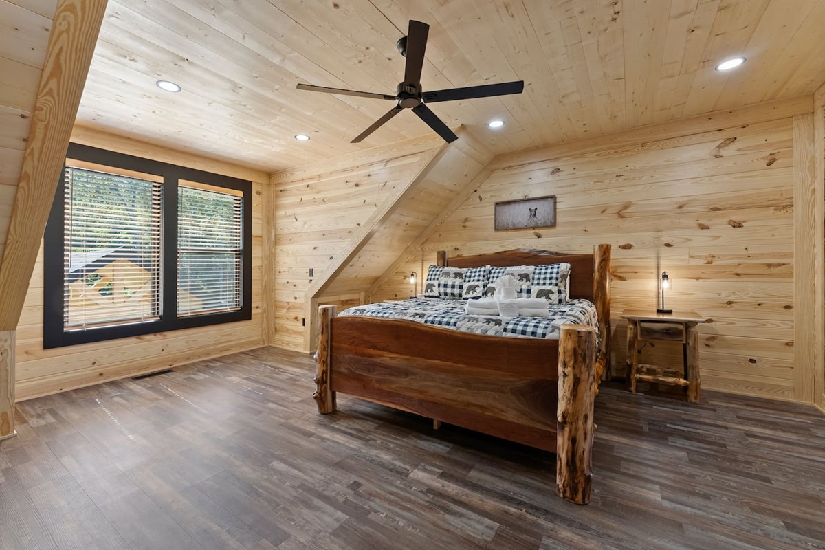 Enjoy mountain cabin charm in this upstairs suite with a handcrafted king bed, sloped ceilings, and serene woodland views.