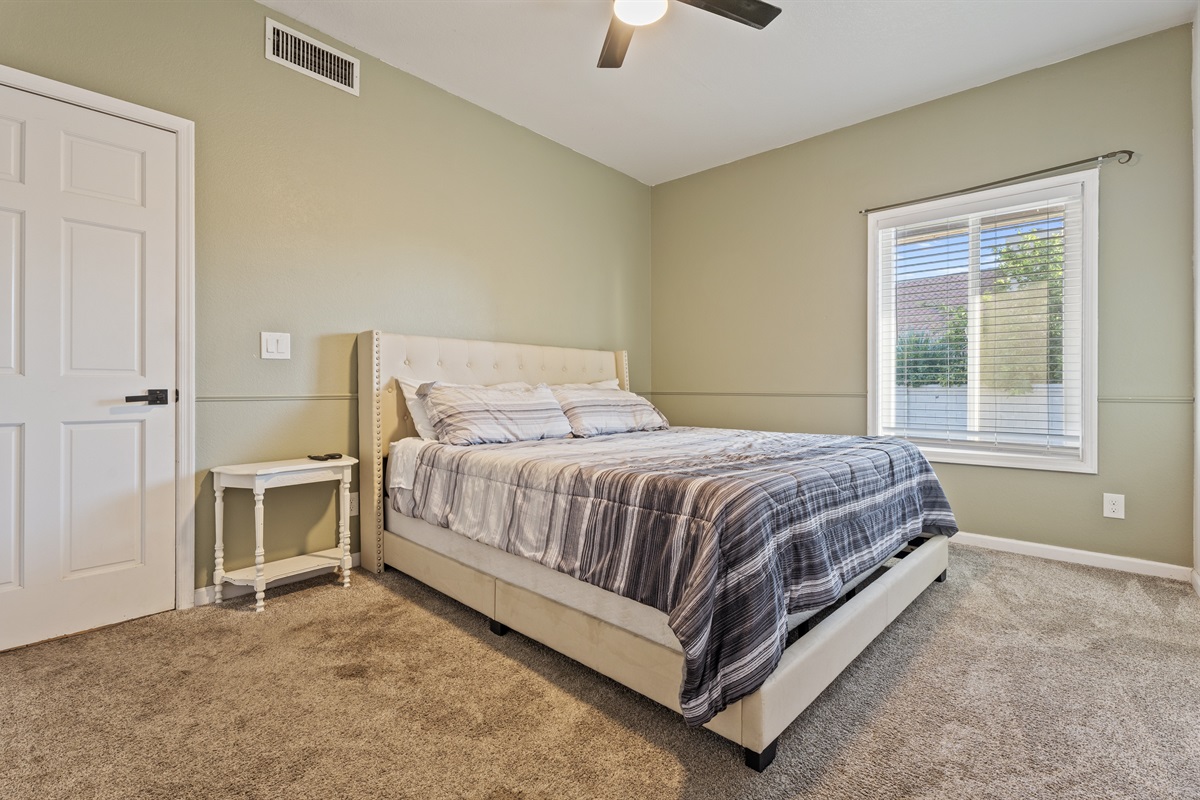 Peaceful and earthy, this relaxing bedroom features a queen bed, soft tones, and a calming corner to truly unwind.