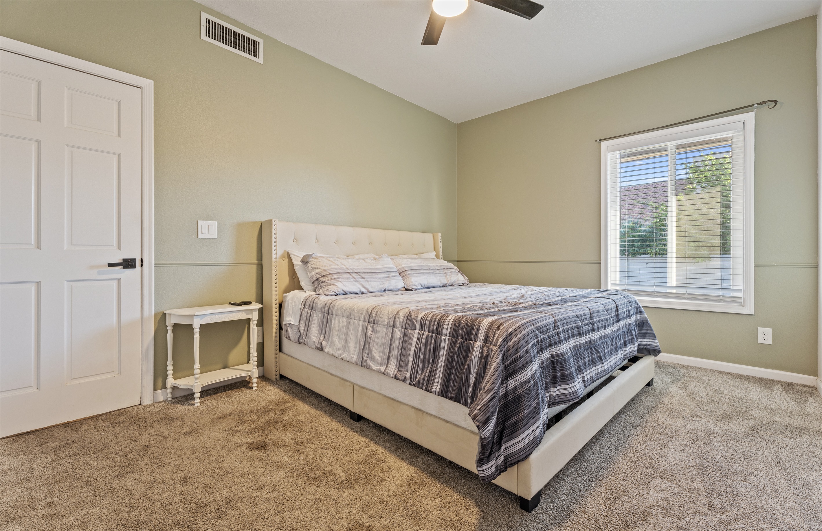 Peaceful and earthy, this relaxing bedroom features a queen bed, soft tones, and a calming corner to truly unwind.