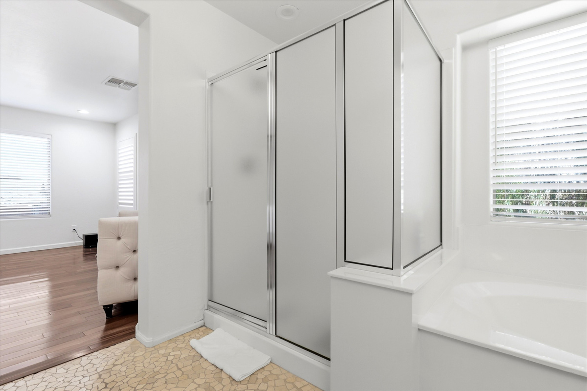 Bathroom with a separate shower, soaking tub, and easy access from the bedroom.
