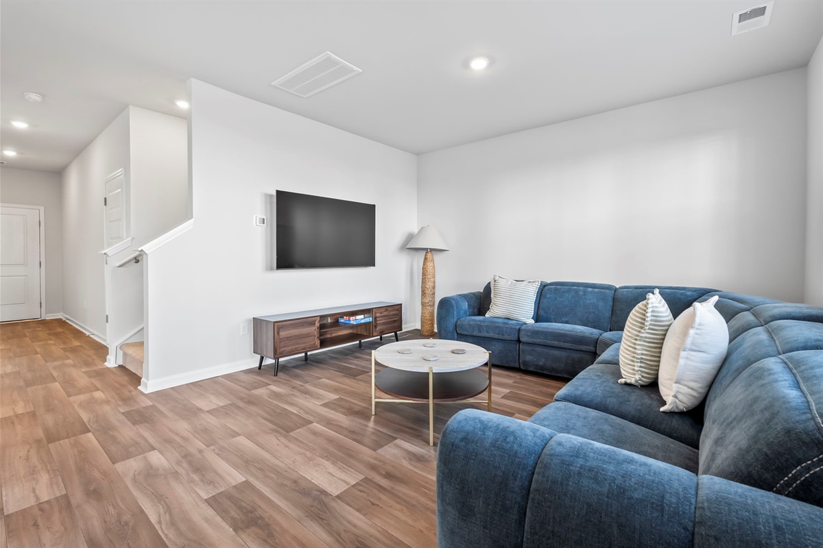 Living room with large wrap around couch and Roku Smart TV