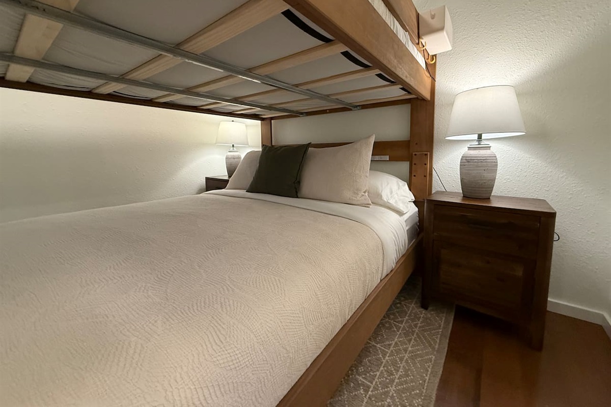 Nightstands with a lamp and electrical outlets and USB outlets on either side of the bed. 