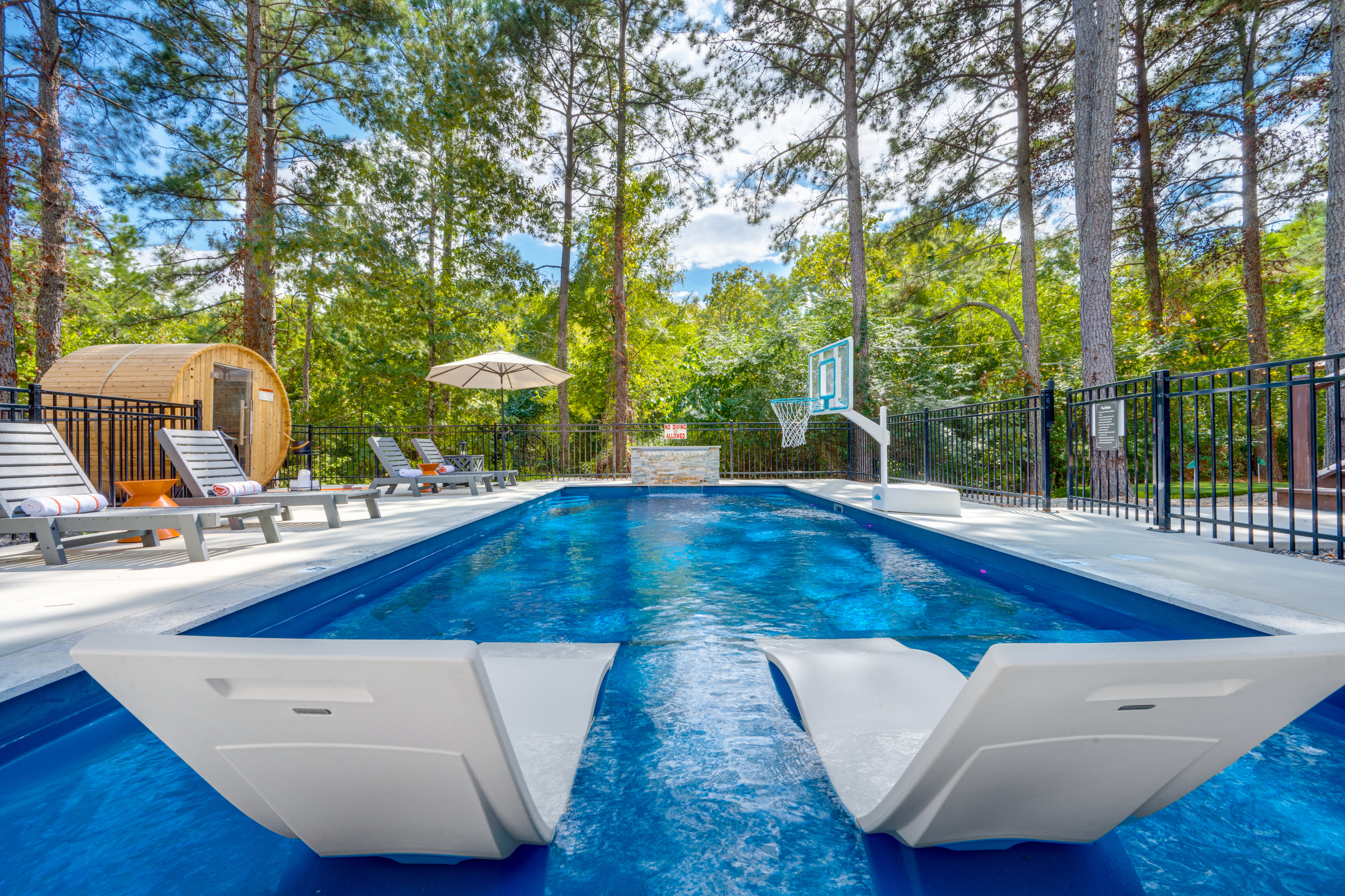 Towering pines wrap around the heated pool, creating a peaceful setting where you can float beneath the pines, lounge by the water, unwind in the cedar sauna, and feel completely removed from the everyday.