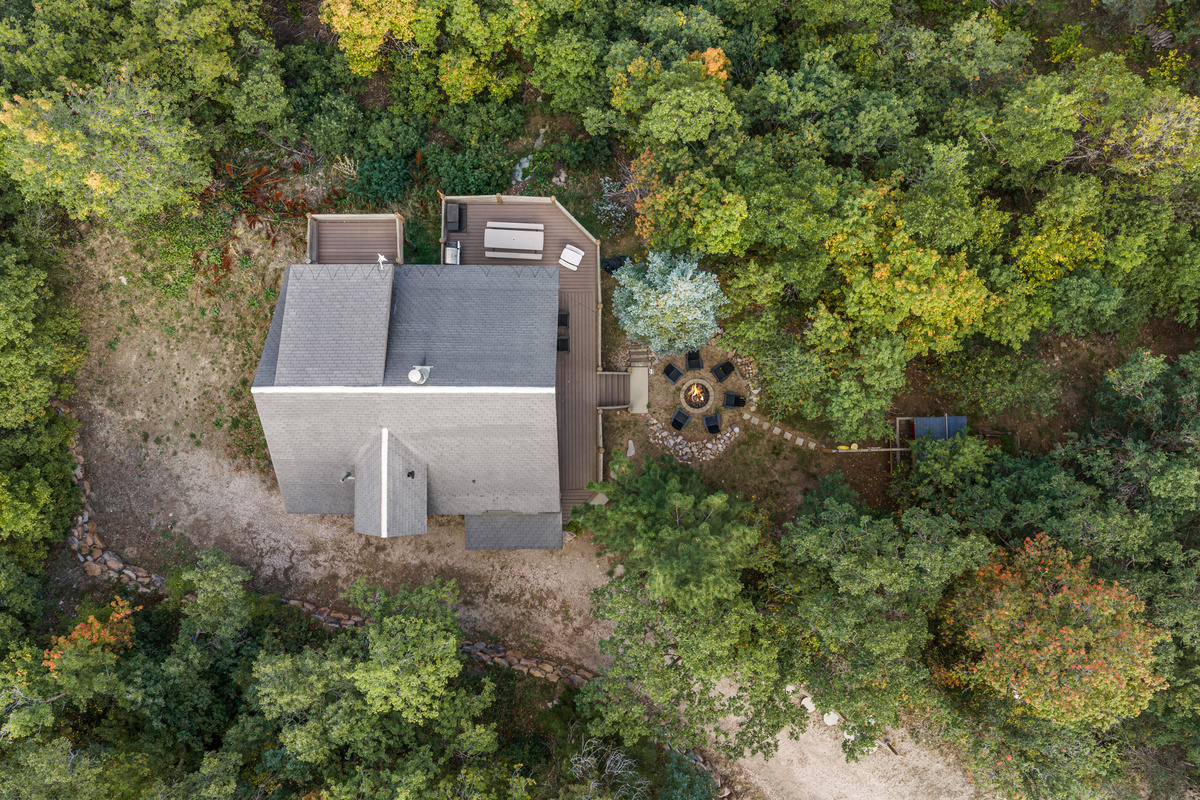 Aerial view highlighting the cabin’s secluded setting among mature trees.