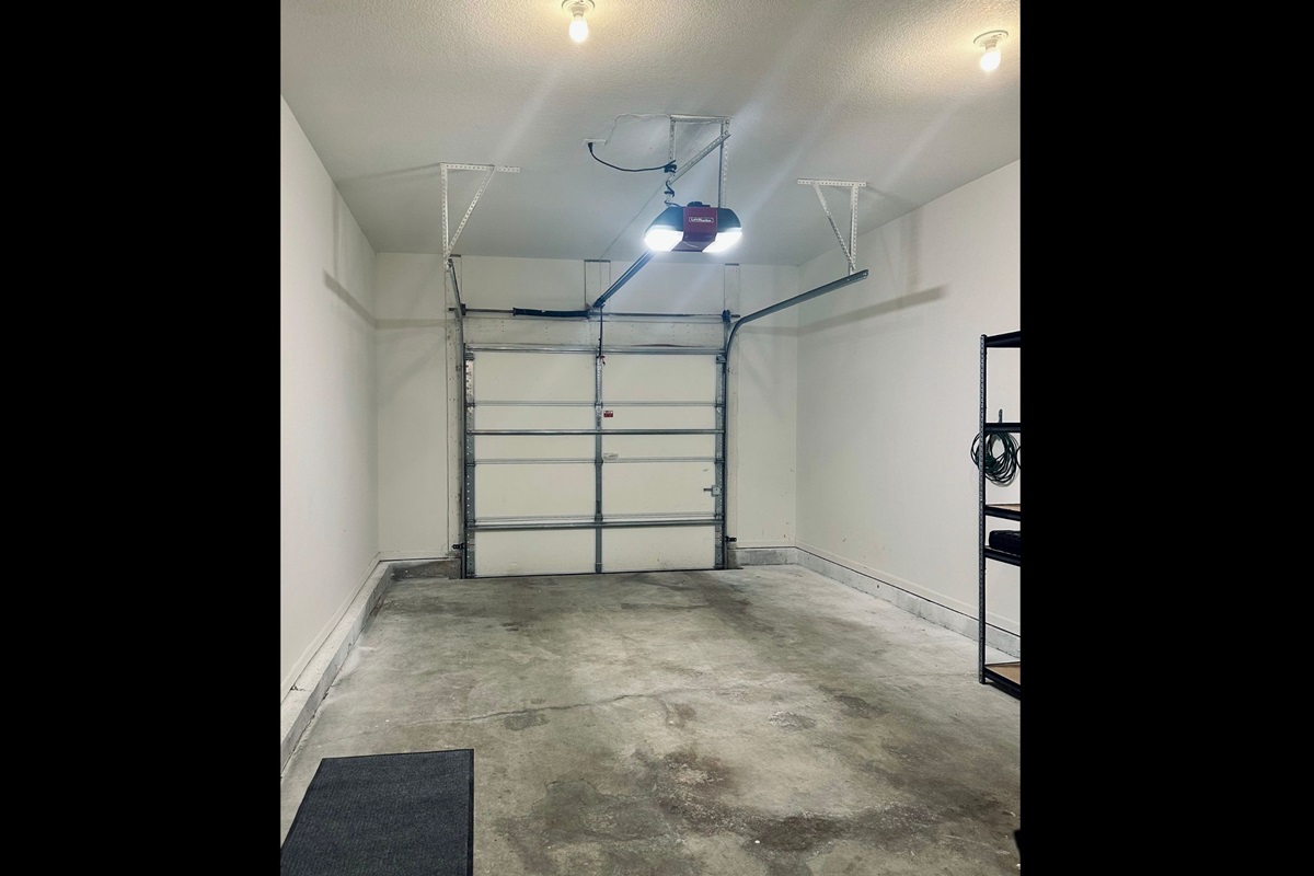 Standard one-car garage offering secure covered parking with additional side space for practical storage and shelving.
