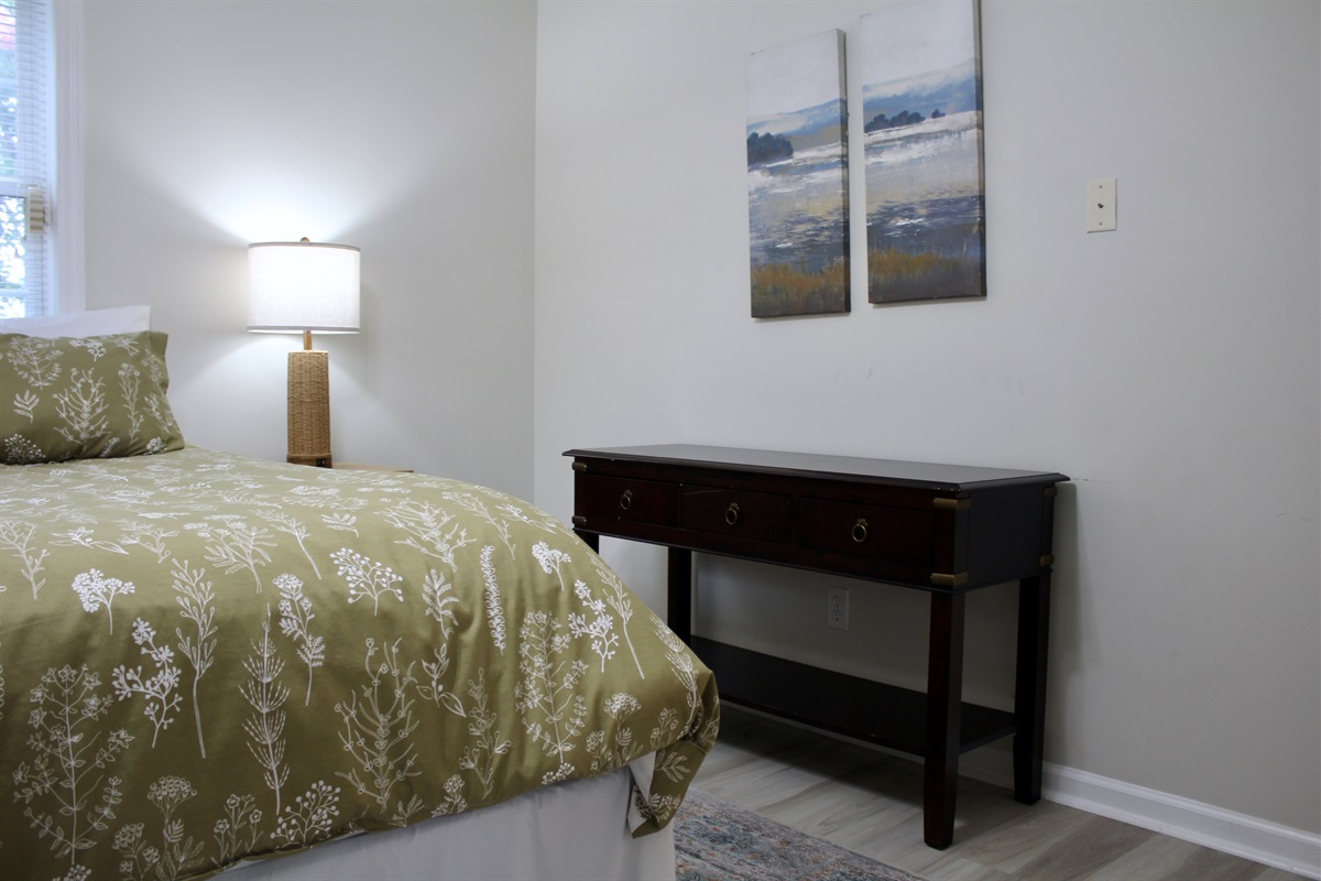 Scenic artwork and soft linens complete this calming bedroom escape.