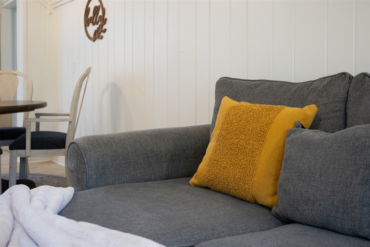 Sink into the plush sofa, complete with soft pillows that invite you to relax and stay a while.