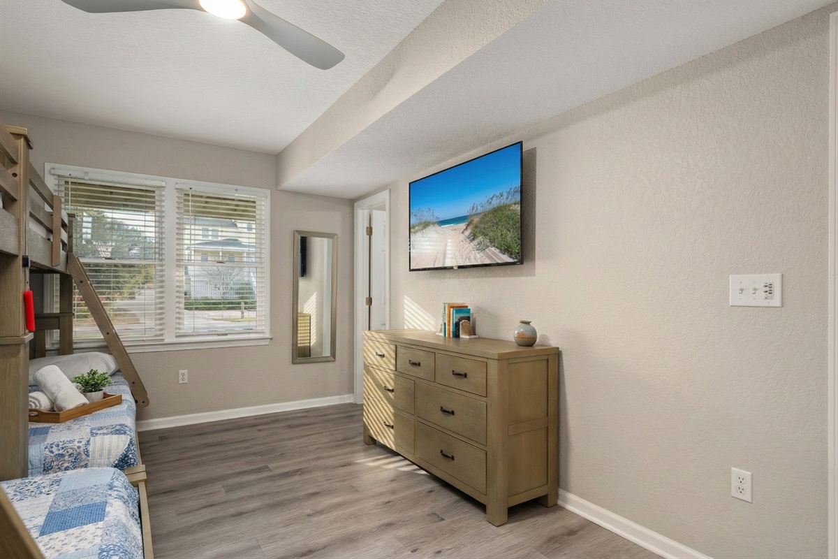 Cozy bedroom with a large TV and warm neutral tones for a restful retreat.