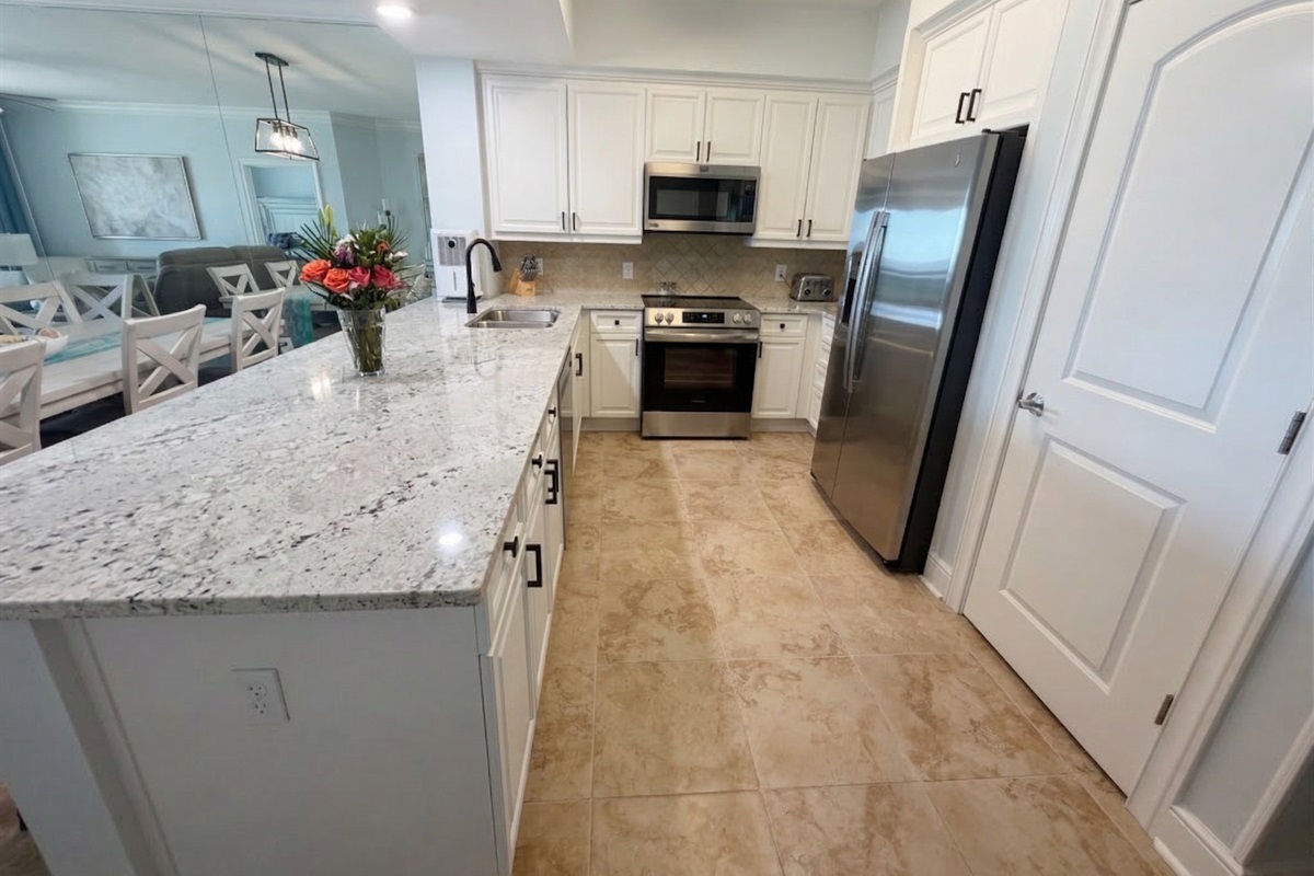 Spacious kitchen with granite countertops, stainless appliances, and bar seating—perfect for coffee mornings or family meals together.
