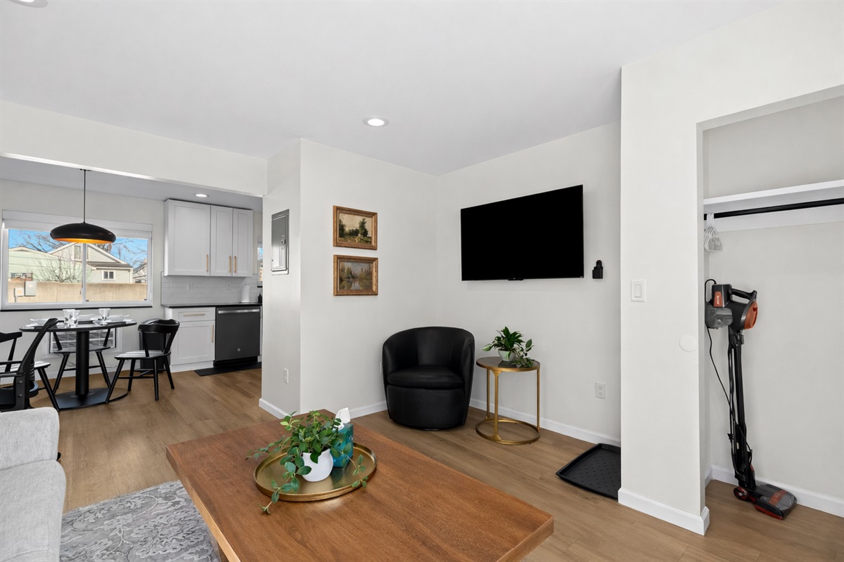 Relax in this bright, modern living space with cozy seating, smart TV, and an open layout that flows seamlessly into the dining area and kitchen.