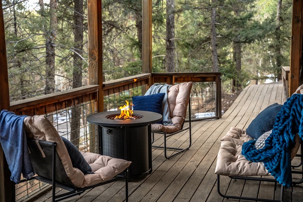 🔥🌲 Cozy deck lounge with cushy chairs, blankets, and a fire table—perfect for sipping, chatting, and unwinding with peaceful forest views ✨🥂