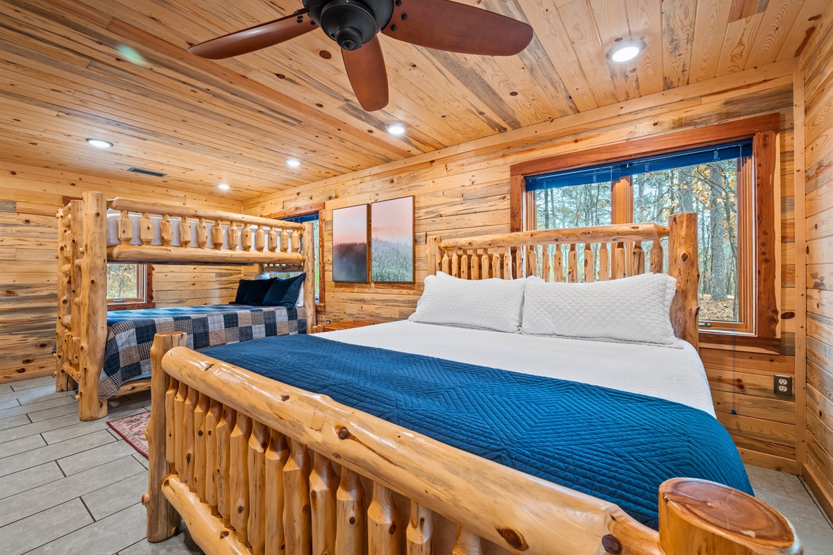 Warm wood accents and comfortable bedding give this sleeping space a relaxed, inviting cabin atmosphere.