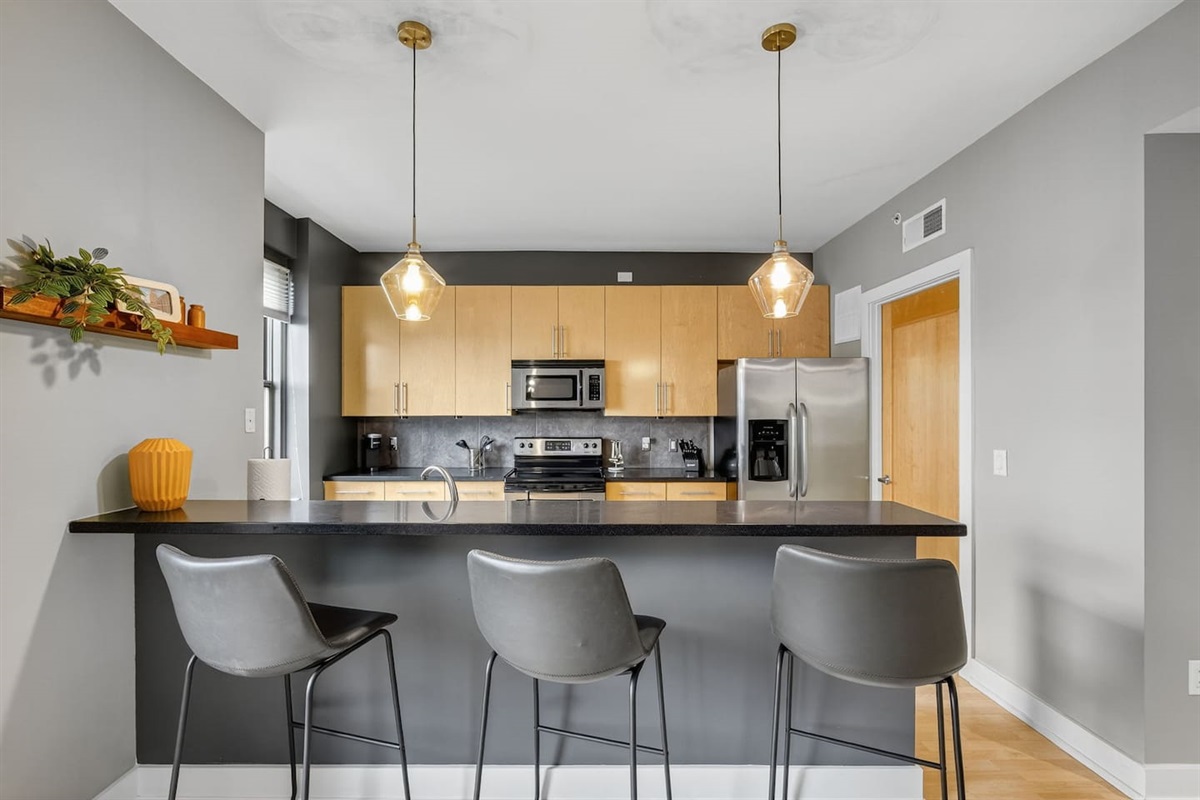 Cook with ease in this fully equipped kitchen featuring stainless appliances, maple cabinetry, and granite countertops. The open bar invites conversation, making it the heart of your downtown Des Moines getaway.